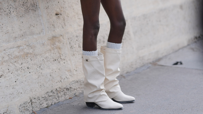 Femme portant des bottes blanches
